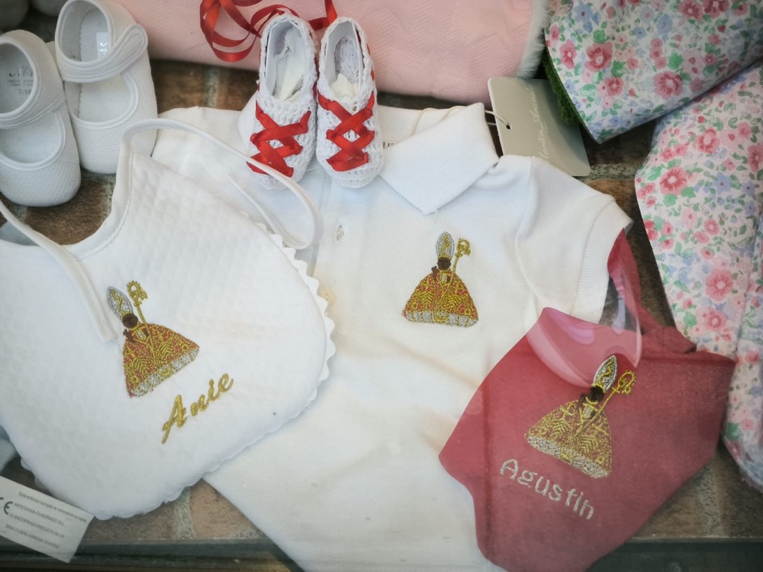 Babero y ropa de bebé bordados con San Fermín y los nombres Anie y Agustín